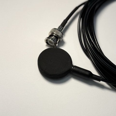 AquaHear 1.5 hydrophone, a 32 mm disc on a coiled black cable, seen from the cable side.